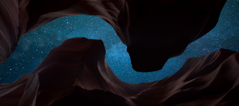 Starry night sky viewed from within a narrow sandstone canyon.