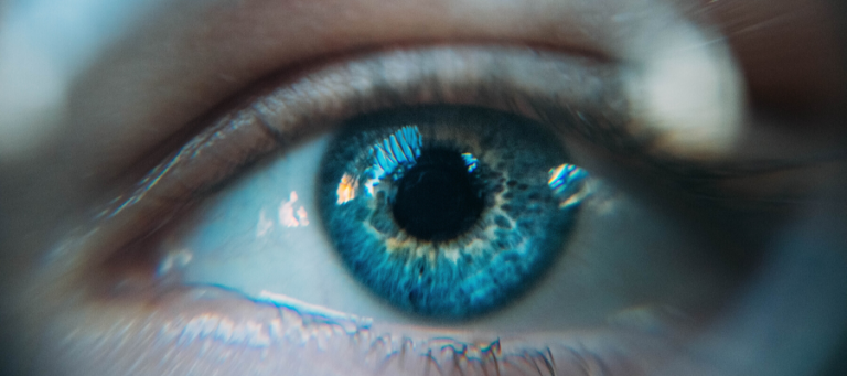 Close-up of a blue eye, reflecting light.