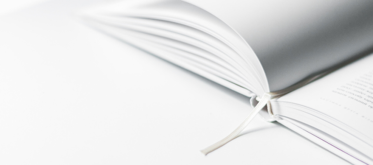 Open book with white pages and a white ribbon bookmark.