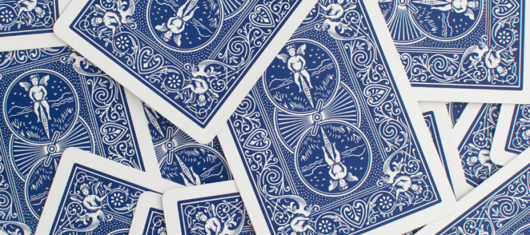 Close-up of blue playing cards, showing intricate designs.