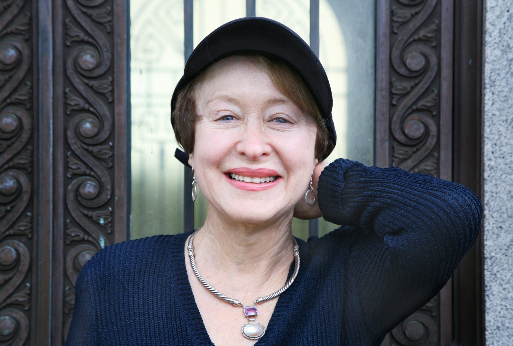 Happy mature woman wearing a baseball cap and necklace