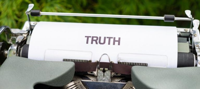 Vintage typewriter with paper that reads "TRUTH".