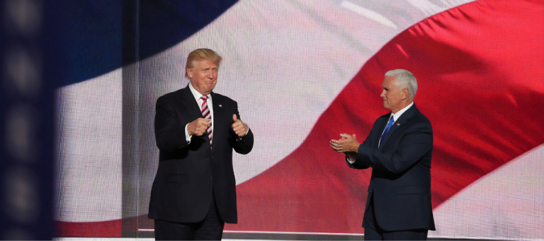 Donald Trump and Mike Pence giving thumbs up at a political event.
