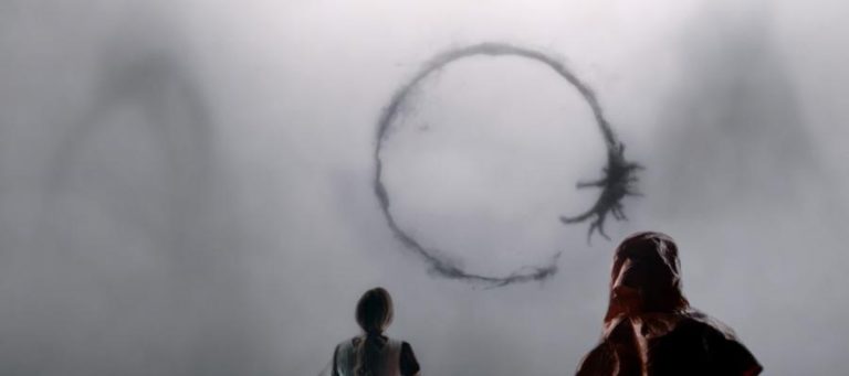Two figures stand before a large, dark ring symbol in a misty landscape.