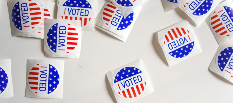 Several "I Voted" stickers on a white surface.