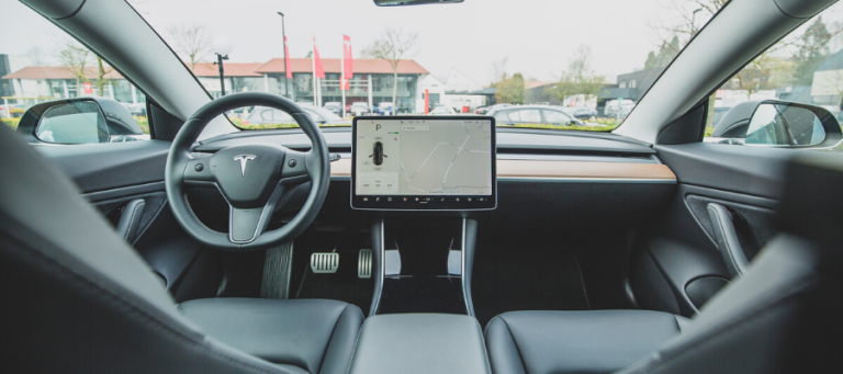 Tesla Model 3 interior with navigation displayed on central touchscreen.