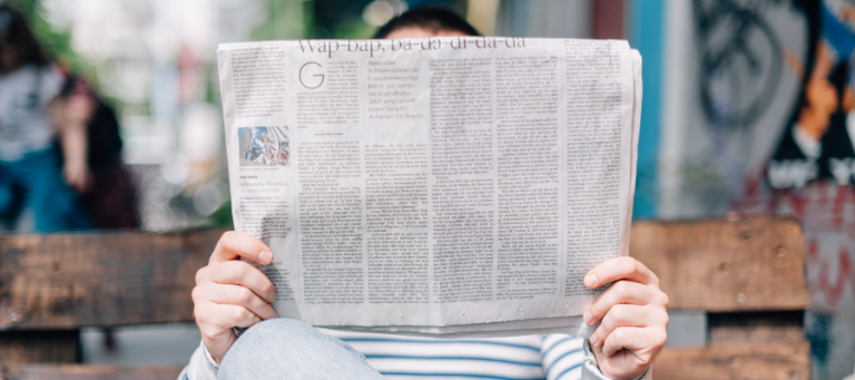 Person reading a newspaper on a park bench. "Wap-bap, ba-da-da-di-da-da" headline visible.