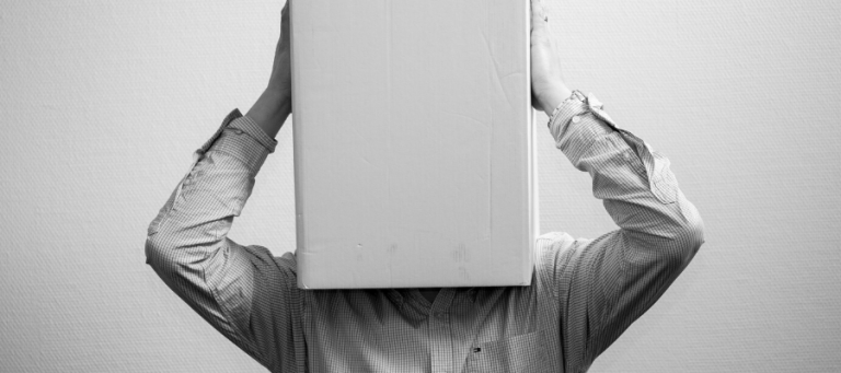 Person with head covered by a box, questioning the definition of a criminal.