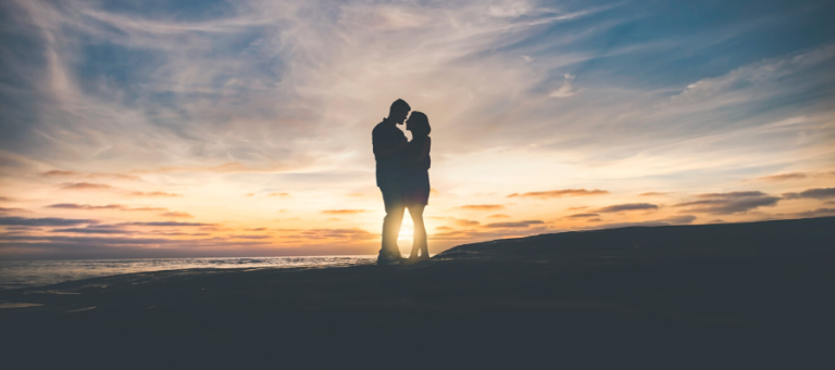 Silhouette of a couple embracing at sunset.