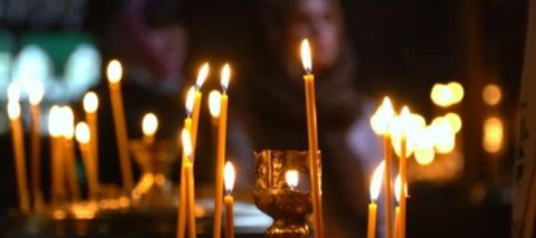 Many lit candles burning in a church