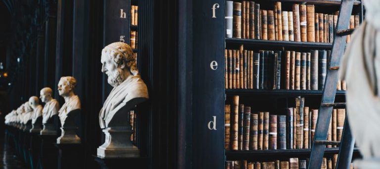 Busts of philosophers in a library, exploring if philosophy offers guidance during crises.