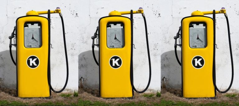 Three vintage yellow gas pumps with a "K" logo.