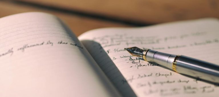 Open notebook with fountain pen, handwritten notes.