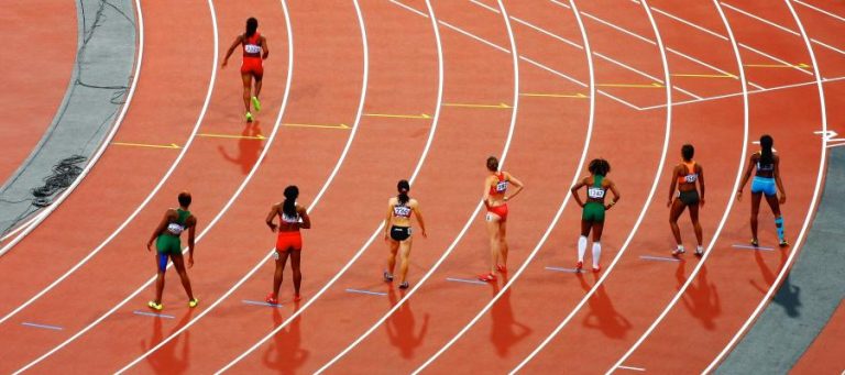 Female track athletes at the finish line of a race.