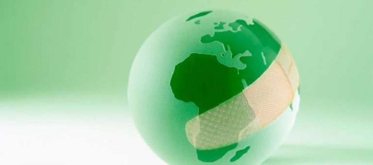 Green globe with a bandage, symbolizing global healing and leadership.