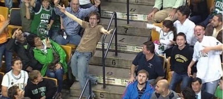 Excited basketball fans cheering at a game.