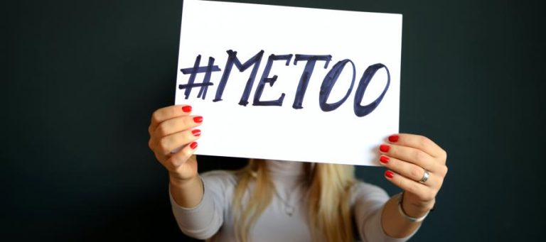 Woman holding a sign that says #MeToo