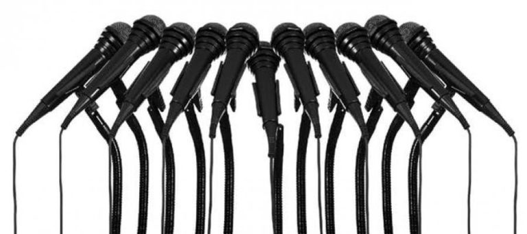 Close-up of multiple black microphones arranged in a row.