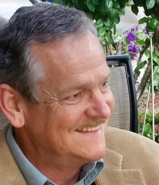 Smiling man outdoors, reflecting a sense of peace and faith.