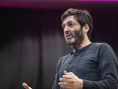 Man speaking, making a point during a presentation on decision-making.