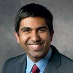 Headshot of a smiling man in a suit