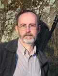 Headshot of a man with glasses and a beard