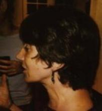 Close-up profile view of a woman with short, dark hair.