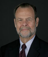 Headshot of a man in a suit and tie.