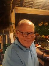 Happy man wearing glasses in a rustic setting.