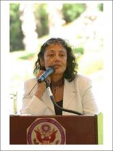 Woman speaking at podium, discussing global identities.