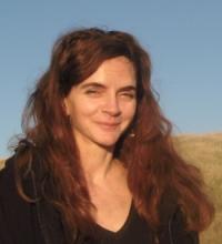 Headshot of a woman with auburn hair, smiling slightly.