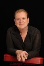 Portrait of a woman, arms folded, demonstrating cooperation.