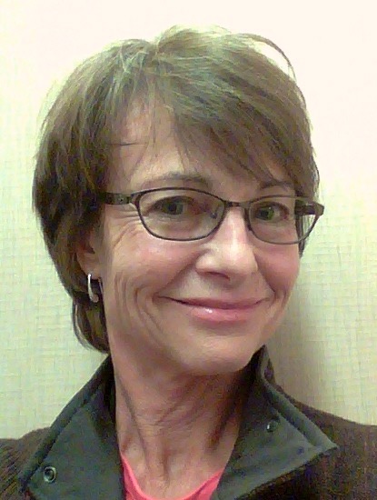 Headshot of a woman with short brown hair and glasses.
