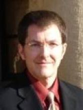 Headshot of a man in a suit and tie