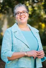 Portrait of Dr. [Last Name], smiling and wearing a light blue jacket.